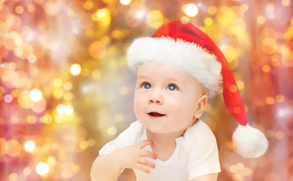 Menino no Natal chapéu de Papai Noel sobre luzes azuis — Fotografia de Stock