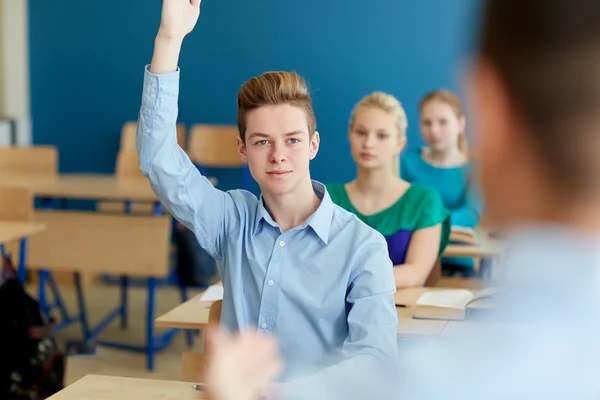 Lycklig student pojke höja handen på skola lektion — Stockfoto