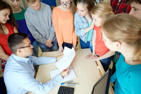 Group of students and teacher with tests at school — Stock Photo, Image