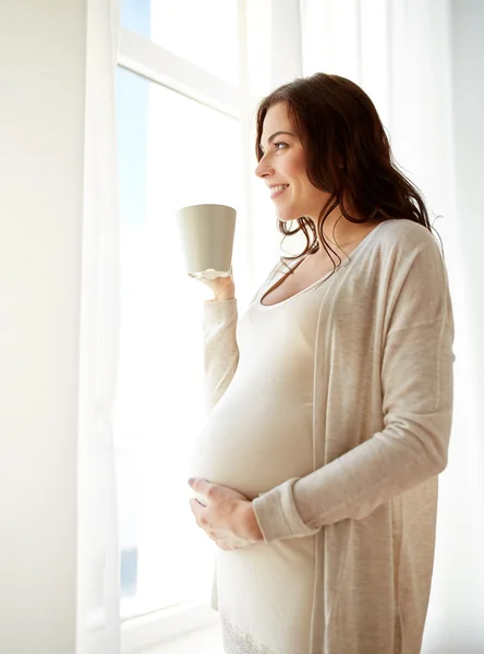 幸福的怀孕女人，坐在家里喝茶的杯 — 图库照片