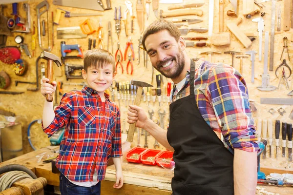 Father and son with hammers working at workshop — Stock Photo, Image