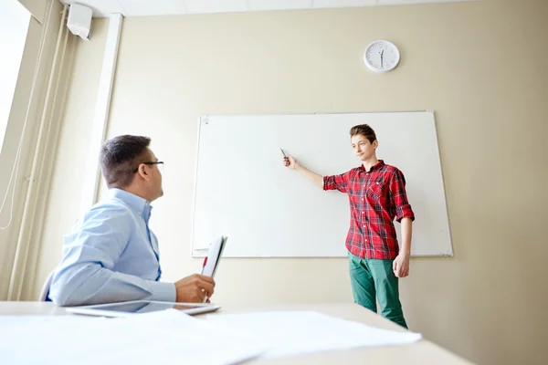 Student boy at school white board and teacher — Stock Photo, Image