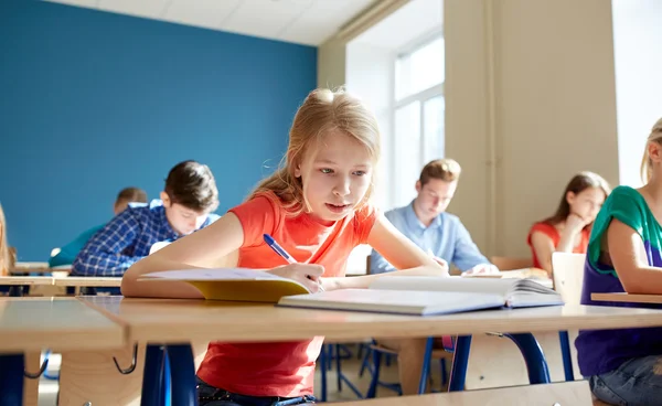 Studente ragazza con libro scrittura scuola test — Foto Stock