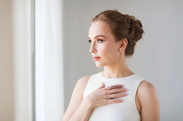 Lächelnde Frau im weißen Kleid mit Diamantschmuck — Stockfoto