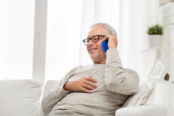 Homem sênior feliz chamando no smartphone em casa — Fotografia de Stock