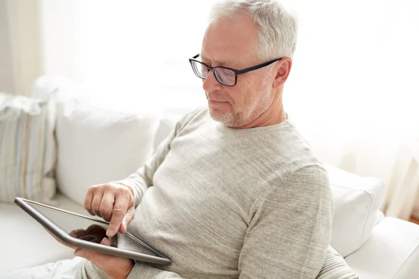 Äldre man med TabletPC hemma — Stockfoto