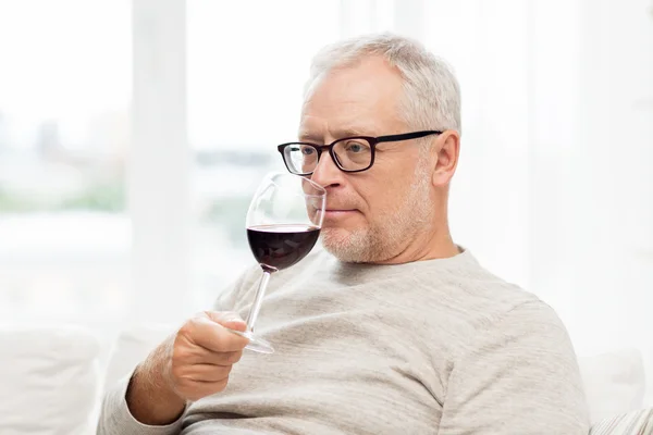 Senior man drinking red wine from glass at home — Stock Photo, Image