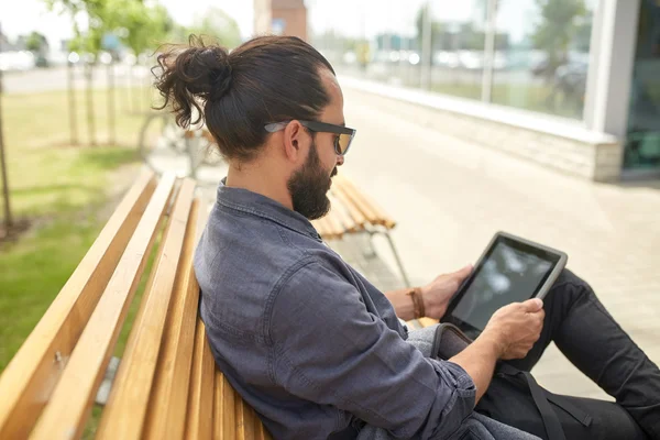 Ο άνθρωπος με το tablet pc κάθεται σε παγκάκι οδών πόλης — Φωτογραφία Αρχείου