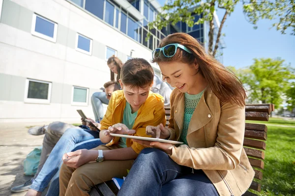 Groep studenten met de tablet pc op schoolplein — Stockfoto