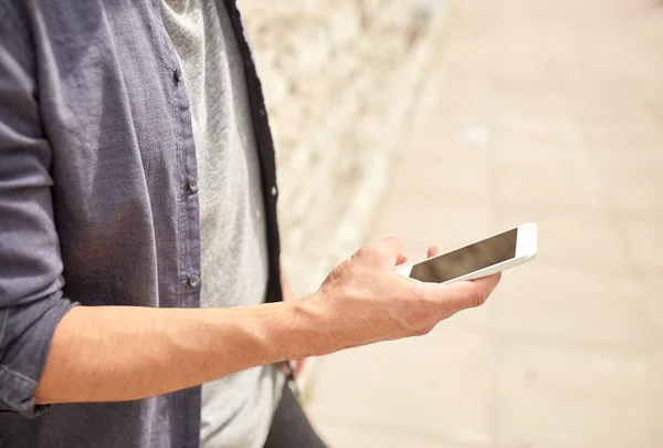 Nahaufnahme von Mann mit Smartphone an Steinmauer — Stockfoto