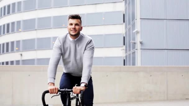 Young man riding bicycle on city street — Stock Video