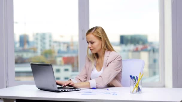 Smiling businesswoman with laptop and papers — Stock Video