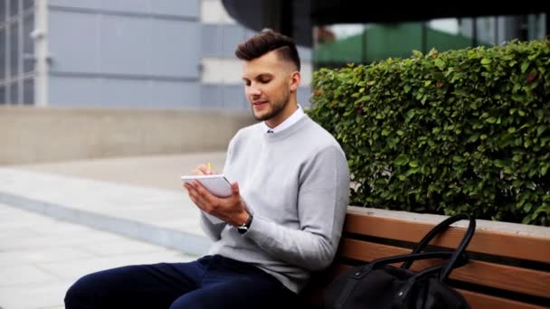 Homme avec cahier ou journal écrit sur la rue de la ville — Video