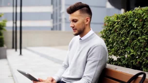 Man with tablet pc sitting on city street bench — Stock Video