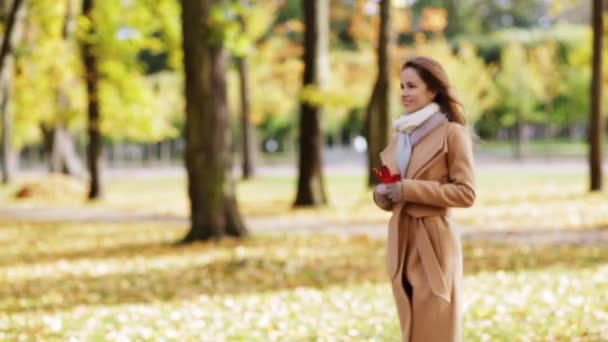 Hermosa mujer joven caminando en el parque de otoño — Vídeos de Stock