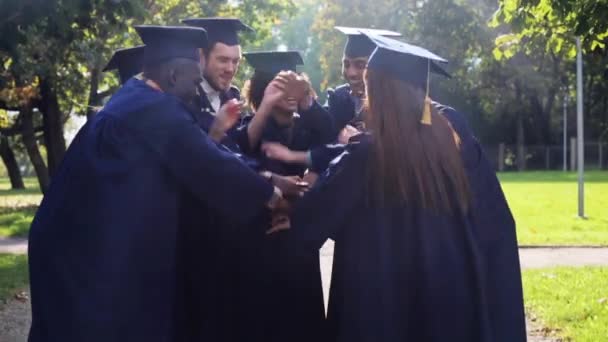 Estudantes felizes em placas de argamassa com as mãos no topo — Vídeo de Stock