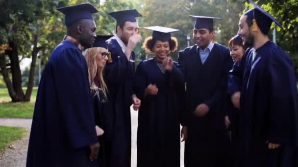 Estudantes felizes em placas de argamassa com as mãos no topo — Vídeo de Stock
