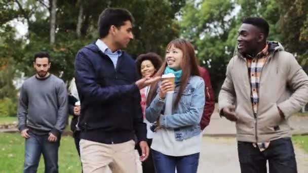 Gelukkige vrienden wandelen langs het herfstpark — Stockvideo