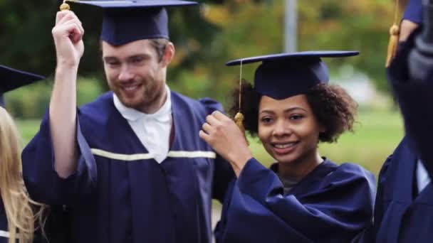 Glückliche Studenten in Mörteltafeln mit Diplomen — Stockvideo