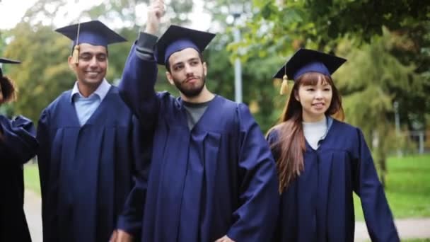 Estudantes felizes em placas de argamassa com diplomas — Vídeo de Stock