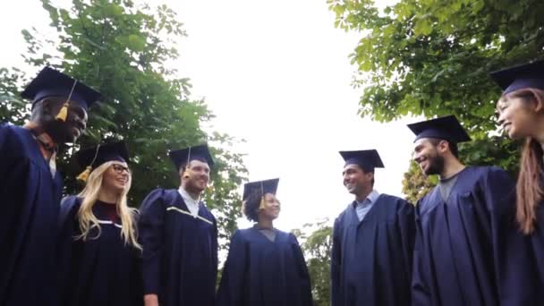 Estudantes felizes jogando placas de argamassa para cima — Vídeo de Stock