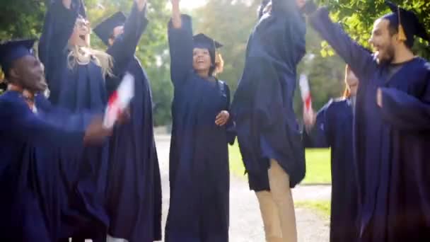 Estudiantes felices en morteros con diplomas — Vídeos de Stock
