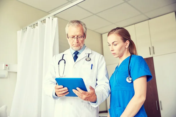 Médico sênior e enfermeira com tablet pc no hospital — Fotografia de Stock