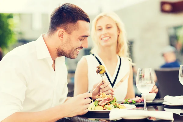 Happy couple eating dinner at restaurant terrace — Stock Photo, Image