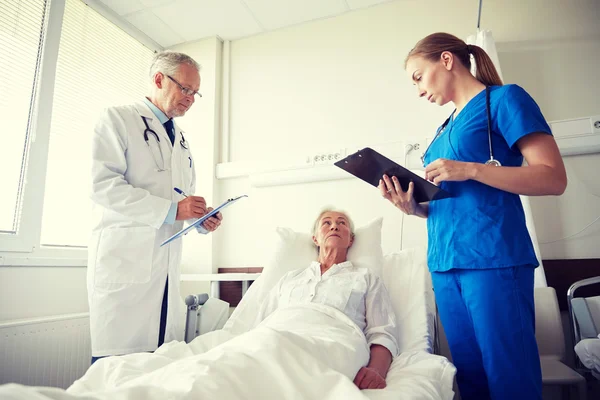 Orvos és nővér látogató magas rangú nő a kórházban — Stock Fotó