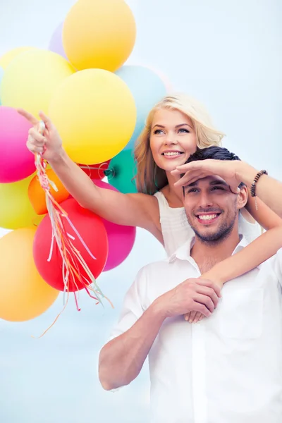 Paar mit bunten Luftballons am Meer — Stockfoto