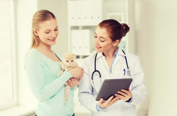 Happy woman with cat and doctor at vet clinic — Stock Photo, Image