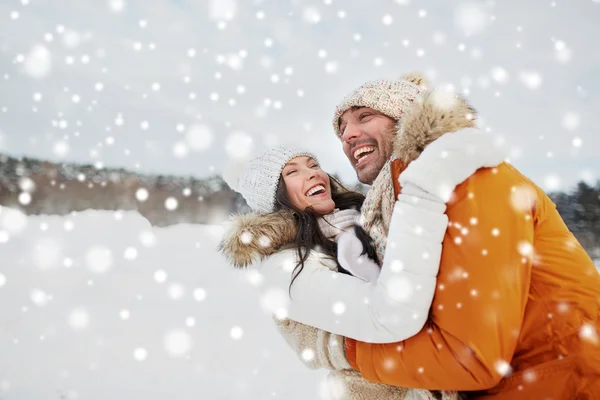 Счастливая пара, обнимающаяся на улице зимой — стоковое фото