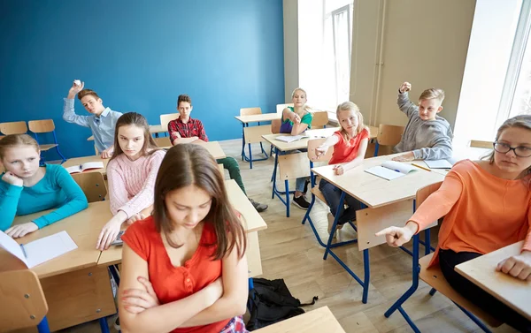 Estudiantes chismorreando detrás de su compañero de clase en la escuela —  Fotos de Stock