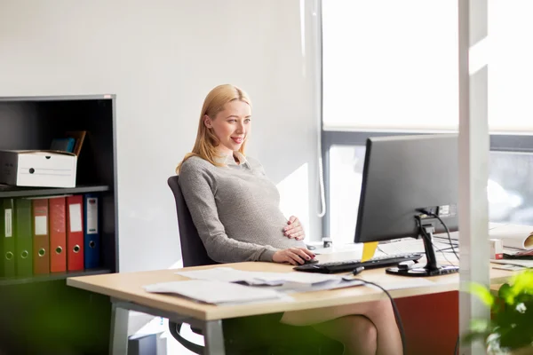 Schwangere Geschäftsfrau mit Computer im Büro — Stockfoto