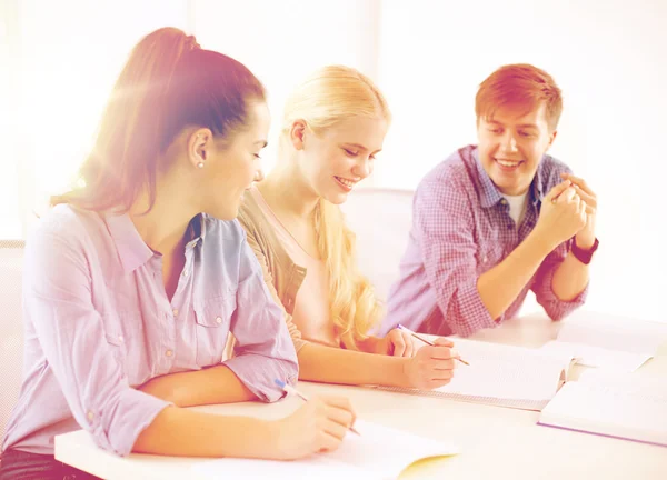 Studenti sorridenti con quaderni a scuola — Foto Stock