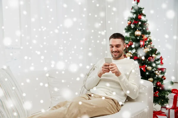 Mosolygó ember smartphone otthon karácsonyra — Stock Fotó