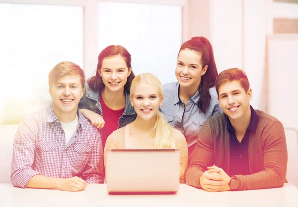 Smiling students with laptop at school — Stock Photo, Image