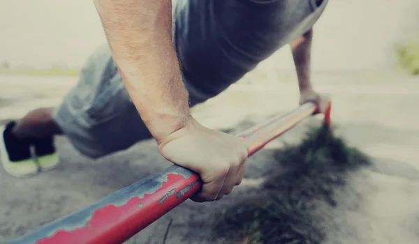 Jongeman die buiten op de horizontale balk traint — Stockfoto