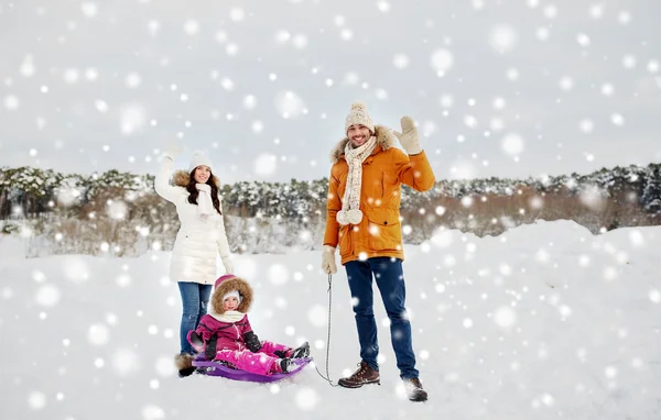 Família feliz com trenó andando no inverno ao ar livre — Fotografia de Stock