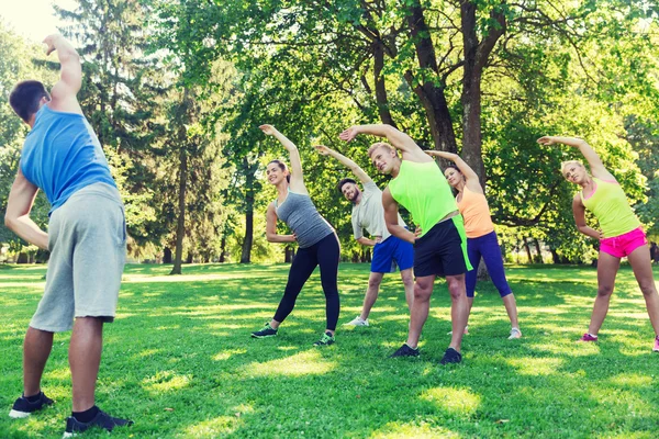 Grupo de amigos o deportistas que hacen ejercicio al aire libre — Foto de Stock