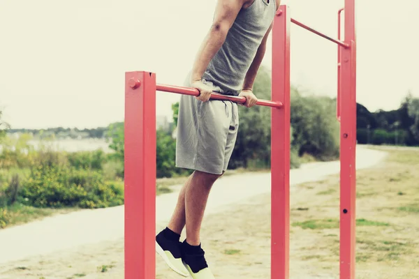 Ung man tränar på vågrät bar utomhus — Stockfoto