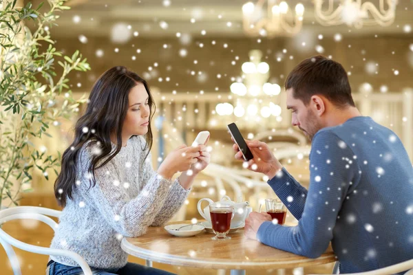 Echtpaar met smartphones thee drinken op café — Stockfoto