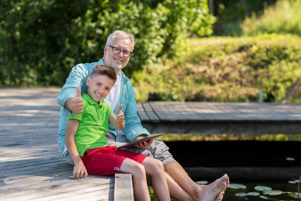 Dědeček a chlapec s tablet pc na říční kotviště — Stock fotografie