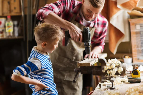 Padre e hijo con taladro trabajando en el taller —  Fotos de Stock