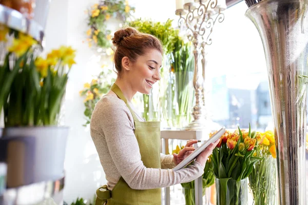 Mujer con la computadora de la tableta en la tienda de flores —  Fotos de Stock