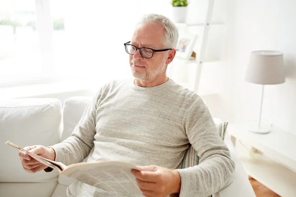 Senior mit Brille liest zu Hause Zeitung — Stockfoto