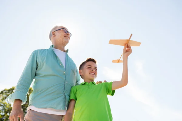 Gökyüzünde oyuncak uçağı olan son sınıf öğrencisi ve çocuk. — Stok fotoğraf