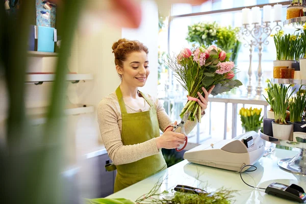 Sonriente florista mujer haciendo ramo en floristería — Foto de Stock