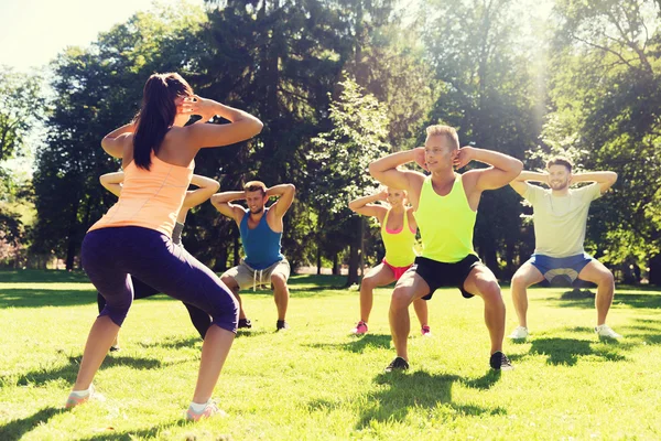 Grupo de amigos o deportistas que hacen ejercicio al aire libre — Foto de Stock