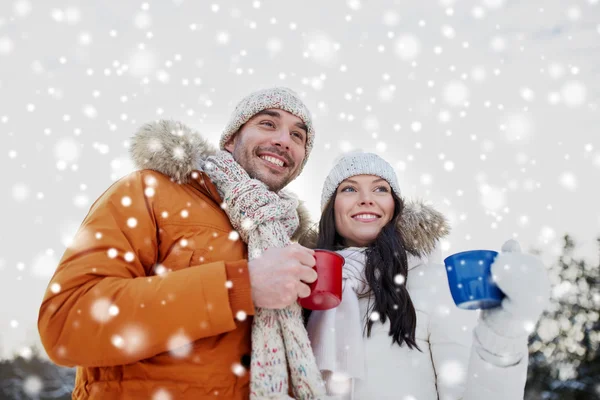 Szczęśliwa para z filiżanki herbaty na zimowy krajobraz — Zdjęcie stockowe